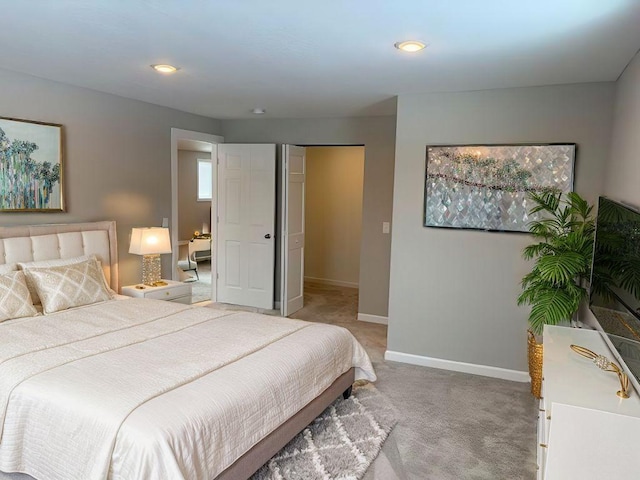 bedroom with light colored carpet and baseboards