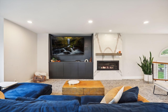 carpeted living area featuring a fireplace, baseboards, and recessed lighting