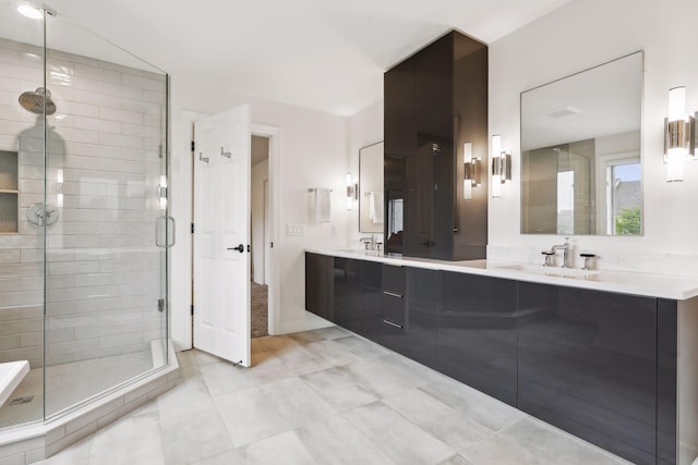 bathroom featuring a stall shower, tile patterned floors, a sink, and double vanity