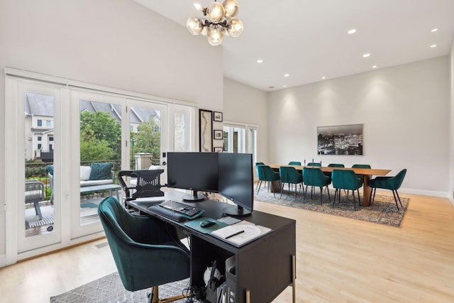 office area with light wood finished floors, baseboards, visible vents, a notable chandelier, and recessed lighting