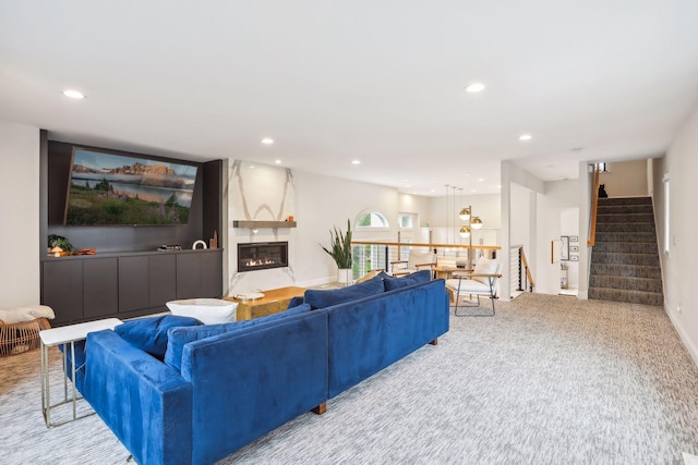 carpeted living area featuring baseboards, stairway, a fireplace, and recessed lighting