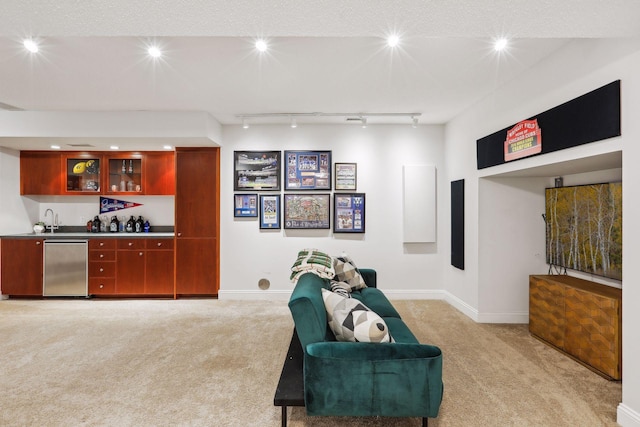 interior space featuring baseboards, wet bar, rail lighting, and light colored carpet