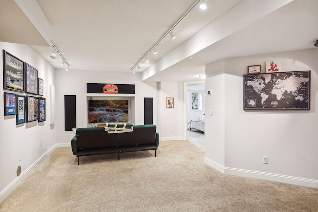 carpeted living area featuring baseboards, visible vents, and track lighting