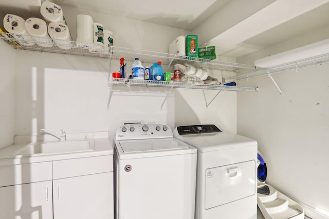 washroom featuring cabinet space, a sink, and separate washer and dryer