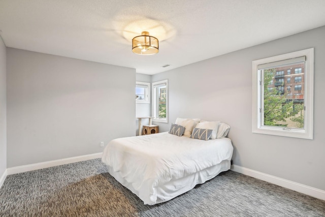 bedroom with carpet floors, multiple windows, and baseboards