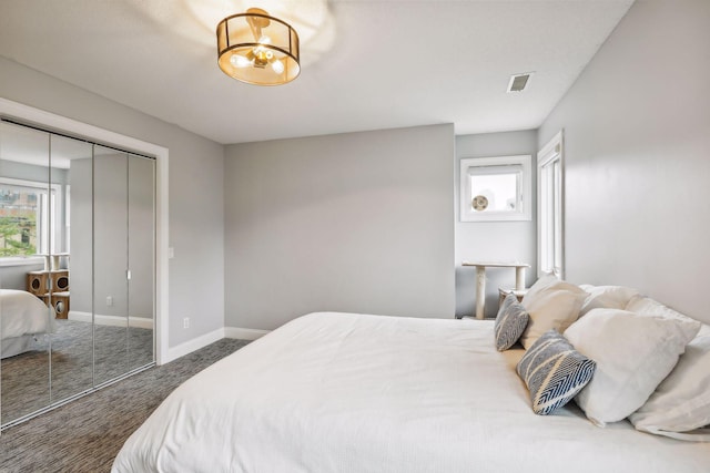 bedroom featuring baseboards, visible vents, an inviting chandelier, carpet floors, and a closet