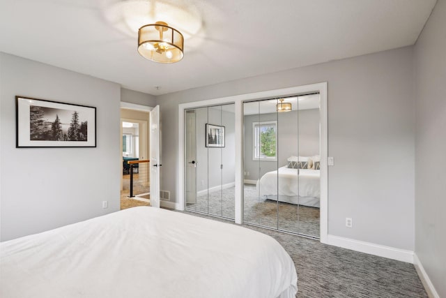 bedroom featuring multiple closets, visible vents, carpet floors, and baseboards