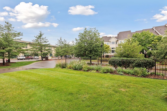 surrounding community with a lawn and fence