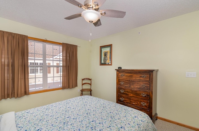 carpeted bedroom featuring ceiling fan, baseboards, and a textured ceiling