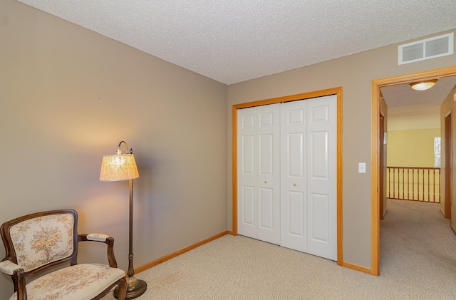 living area with light colored carpet, visible vents, a textured ceiling, and baseboards