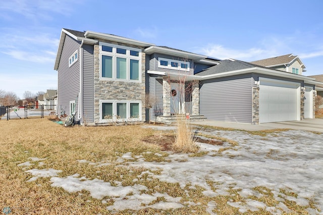 view of front of home featuring a garage, stone siding, fence, and a gate