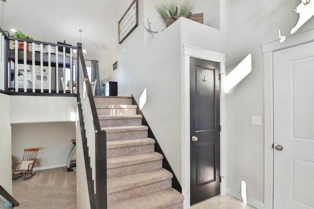 stairs featuring carpet and baseboards