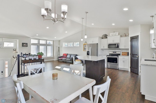 dining room with lofted ceiling, an inviting chandelier, dark wood finished floors, and recessed lighting