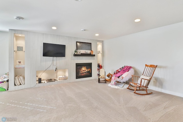 sitting room with a glass covered fireplace, carpet flooring, and recessed lighting