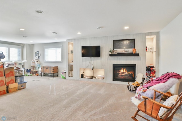 carpeted living area featuring recessed lighting and a large fireplace