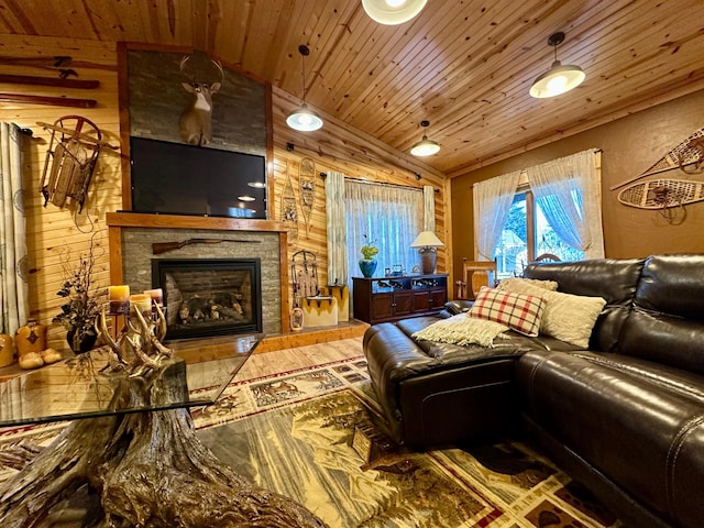 living room with wood ceiling, a fireplace, vaulted ceiling, and wooden walls