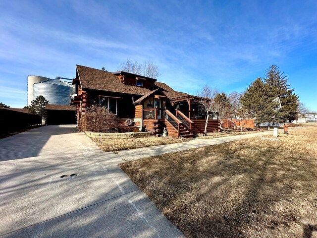 cabin with driveway and log exterior