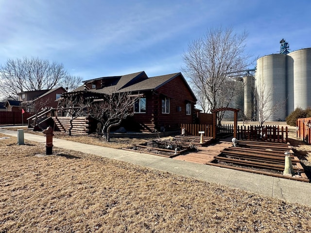 view of property exterior featuring fence, log siding, and roof with shingles