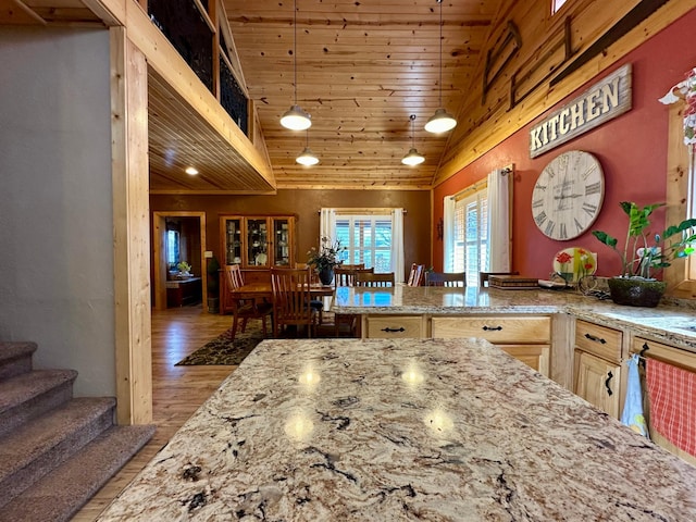 kitchen with light wood finished floors, lofted ceiling, wood ceiling, light stone countertops, and pendant lighting