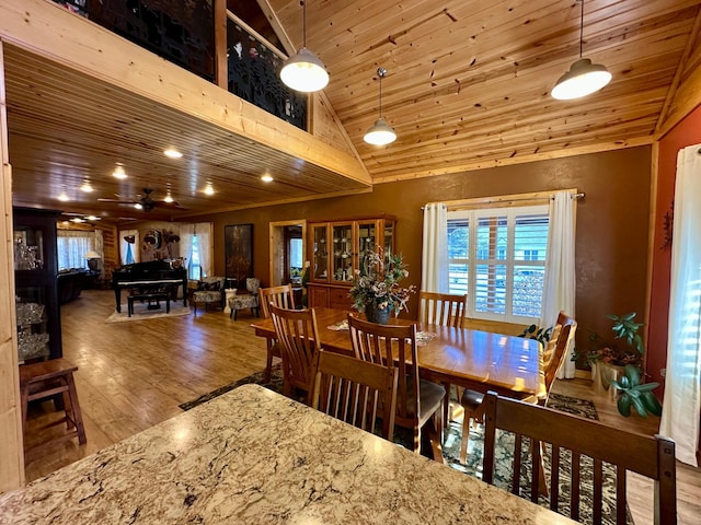 dining area featuring high vaulted ceiling, wood ceiling, and wood finished floors