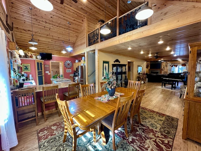 dining room featuring ceiling fan, high vaulted ceiling, hardwood / wood-style flooring, and wood ceiling