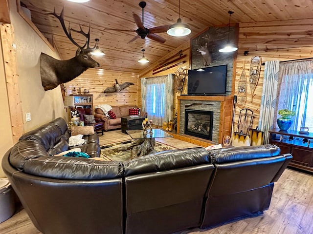 living room featuring a fireplace, wood finished floors, wood ceiling, and wooden walls