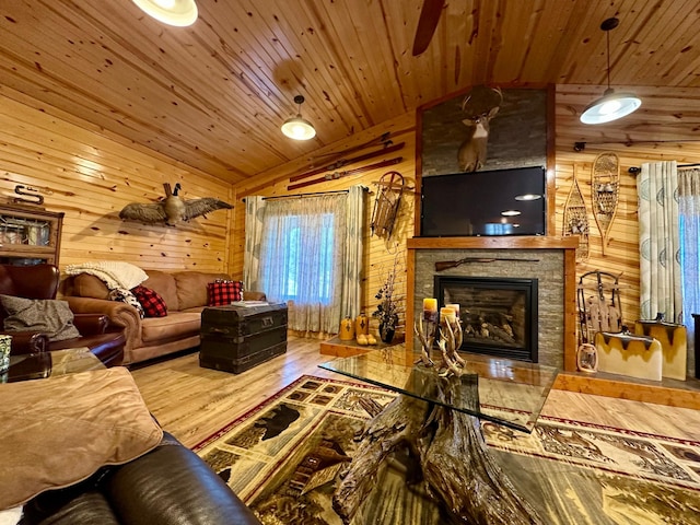 living area with lofted ceiling, wood walls, a fireplace, wood finished floors, and wood ceiling