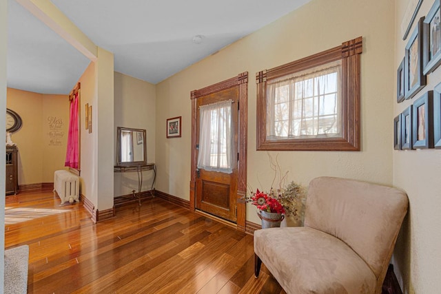 foyer featuring baseboards, radiator heating unit, and hardwood / wood-style flooring