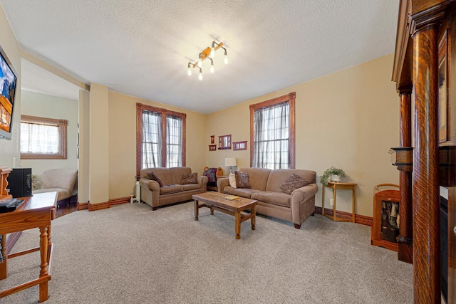 living area featuring light carpet, a textured ceiling, and baseboards