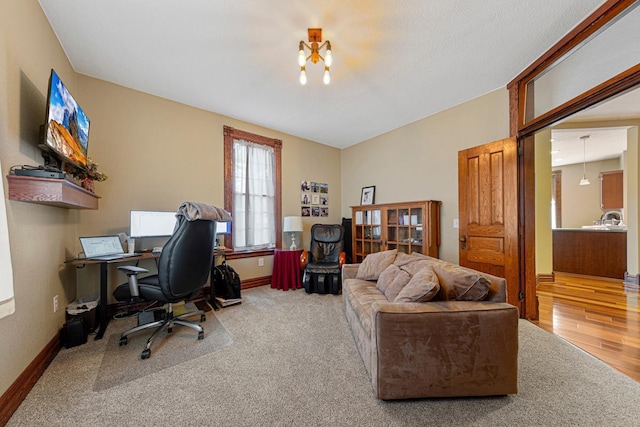 carpeted office with baseboards and wood finished floors