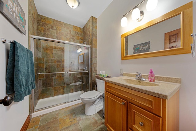 full bath with toilet, a shower stall, stone finish flooring, and vanity