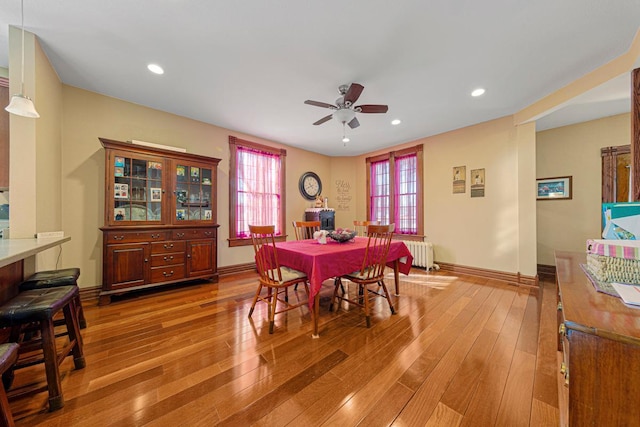 dining room featuring light wood-type flooring, radiator, baseboards, and recessed lighting