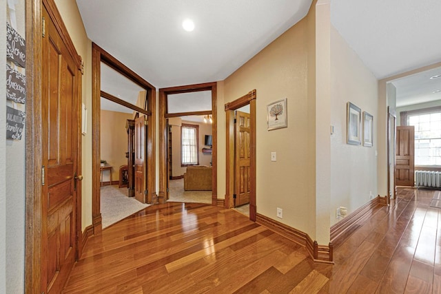 foyer featuring light wood-style floors, baseboards, and radiator heating unit