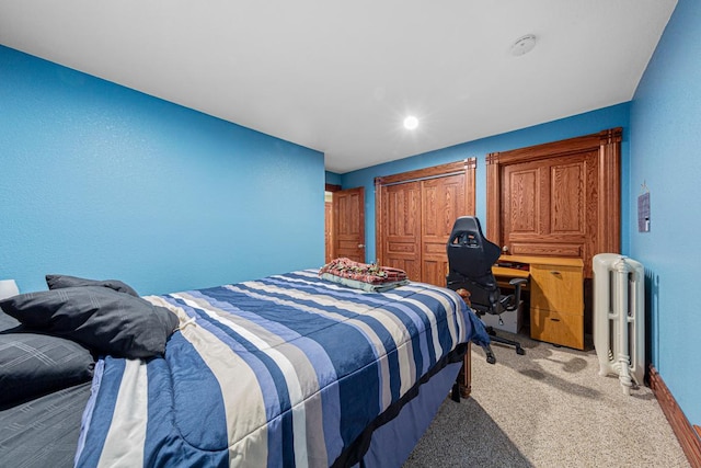 bedroom with light carpet, radiator heating unit, and a closet