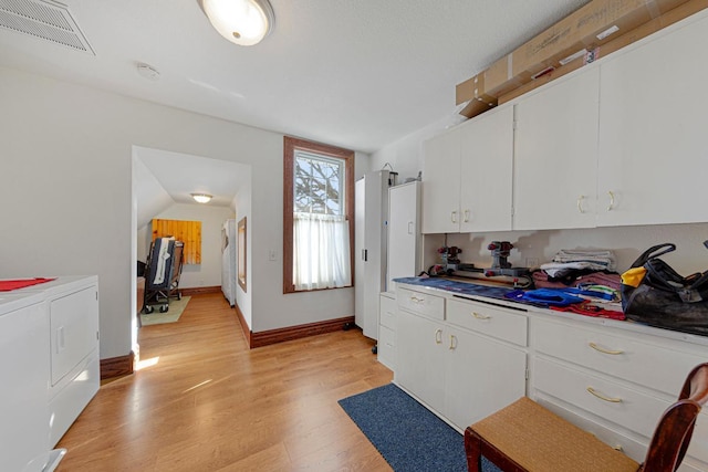 kitchen with light wood-style floors, visible vents, independent washer and dryer, and white cabinetry