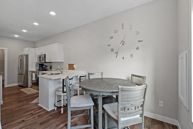 dining area with baseboards, dark wood finished floors, and recessed lighting