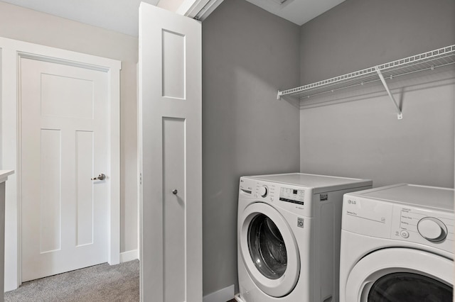 laundry room featuring laundry area, baseboards, washer and clothes dryer, and light colored carpet