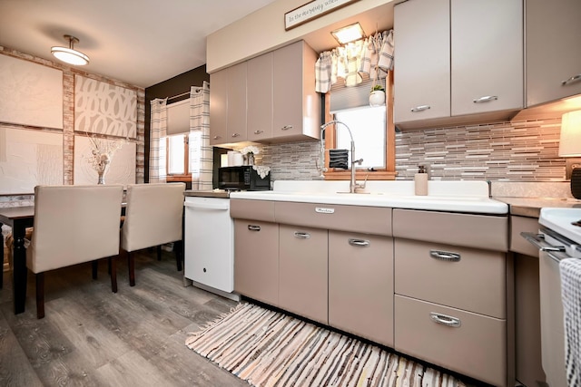 kitchen featuring gray cabinetry, light countertops, light wood-type flooring, and decorative backsplash