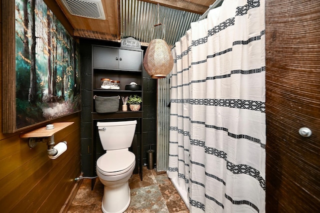 full bathroom with a shower with shower curtain, visible vents, and toilet