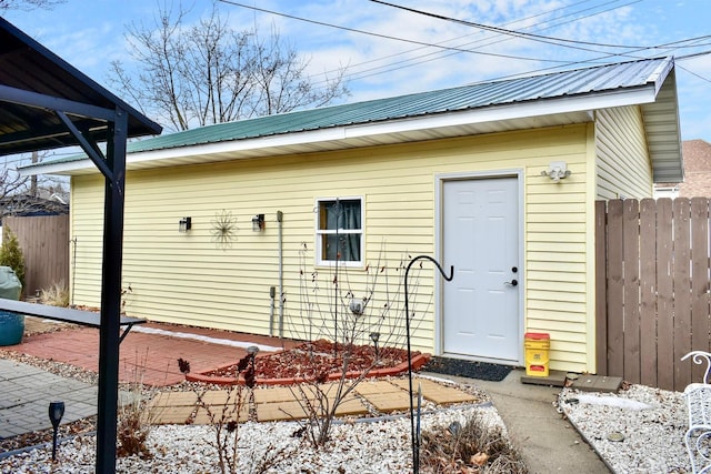 exterior space featuring a patio area, fence, and metal roof