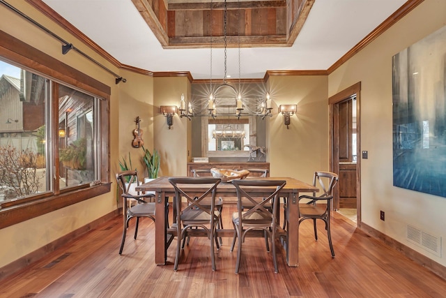 dining area with wood finished floors, visible vents, and baseboards