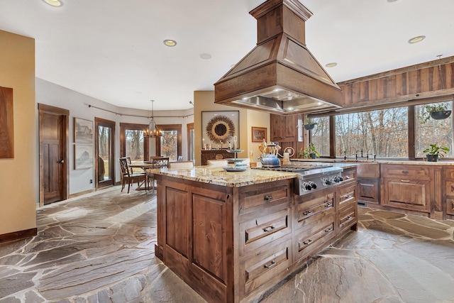 kitchen featuring stainless steel gas cooktop, a kitchen island, marble finish floor, light stone countertops, and island exhaust hood