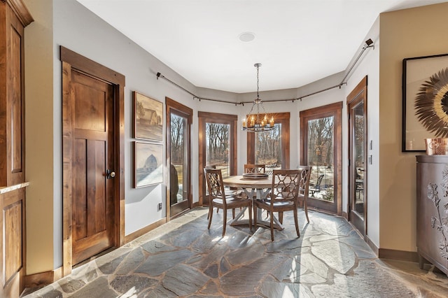 dining room with a chandelier and baseboards