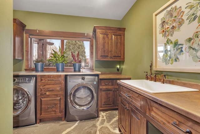 washroom featuring cabinet space, a sink, and washer / dryer