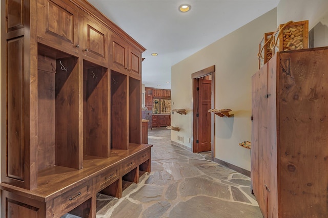 mudroom featuring baseboards, recessed lighting, and stone flooring