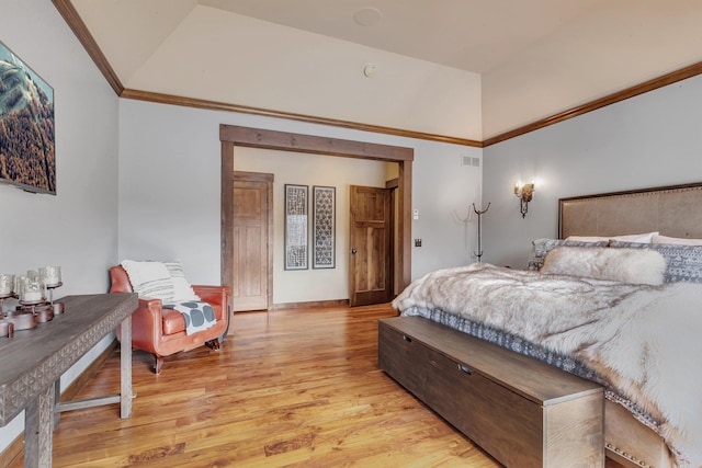 bedroom featuring lofted ceiling, light wood-type flooring, visible vents, and crown molding