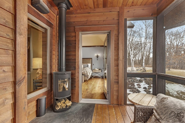 interior space featuring wooden ceiling and a wood stove