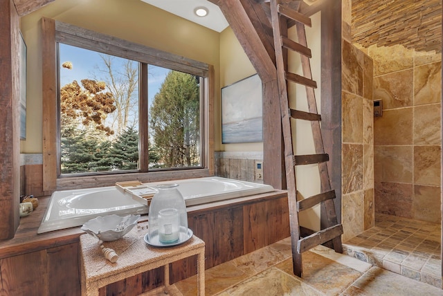 bathroom featuring a wealth of natural light, a garden tub, and tiled shower