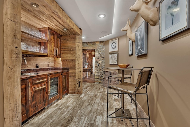 bar featuring baseboards, recessed lighting, and light wood-style floors