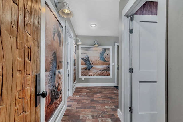 hallway with brick floor, baseboards, and recessed lighting